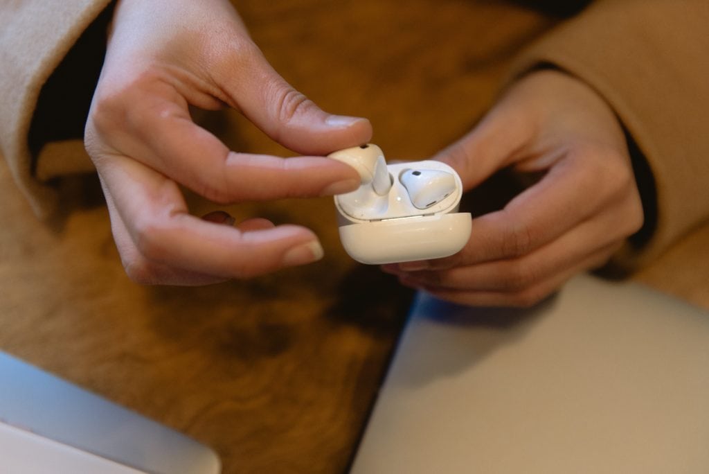 Woman grabbing airpods out of case
