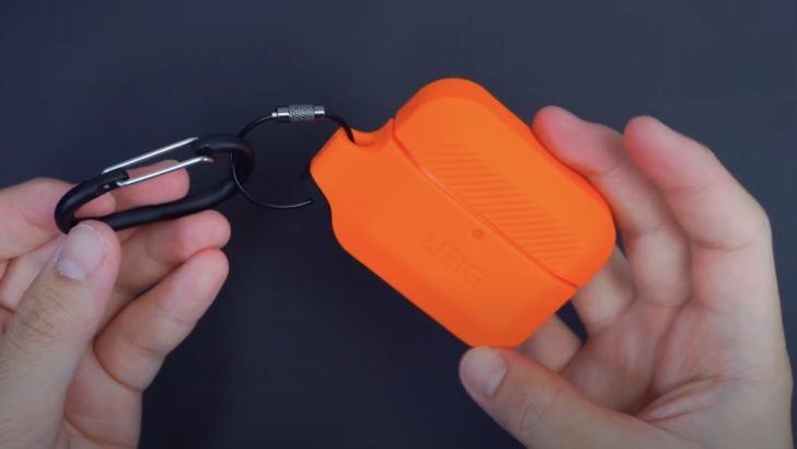 Photo of person holding airpods case cover with strap 