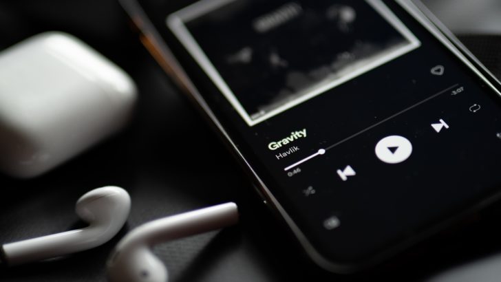 Photo of airpods and iphone playing music on spotify