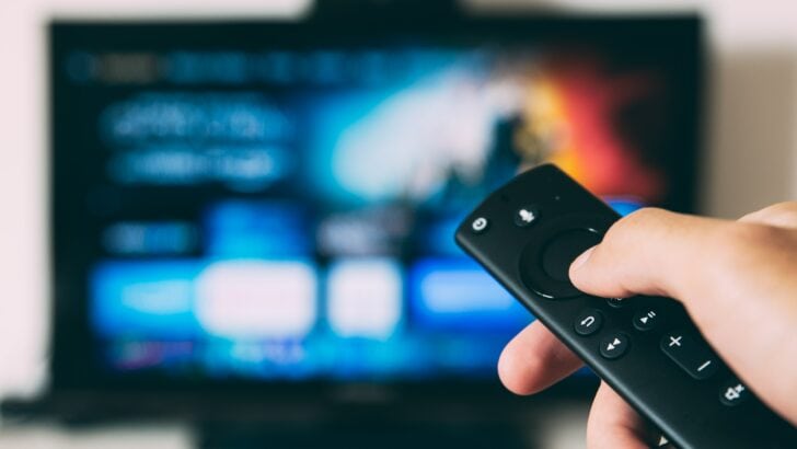 Photo of person using smart tv remote on smart tv