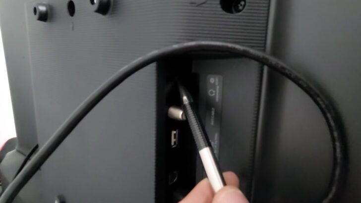 Photo of person using ballpen to reset hisense tv