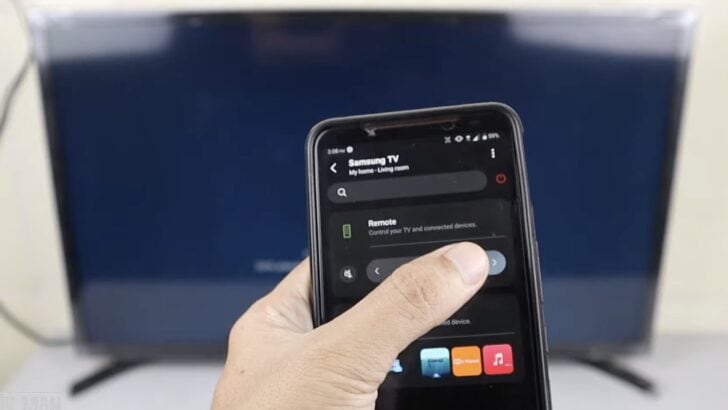 Photo of person using smartthings app on smartphone to control samsung tv