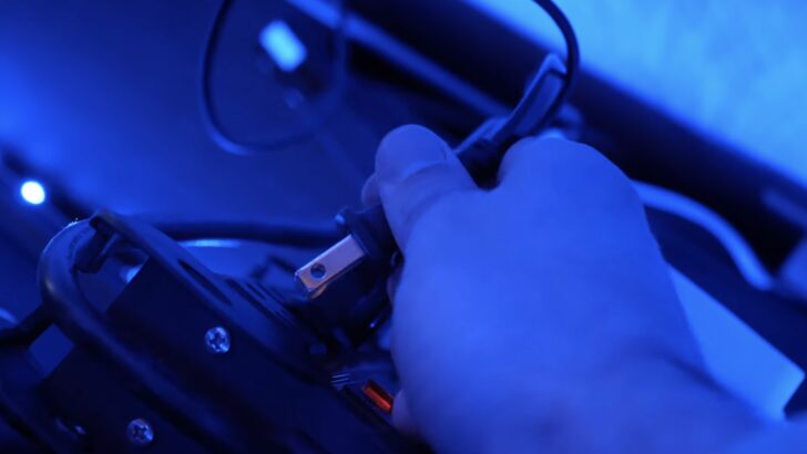 Photo of person unplugging lg tv power cord from a power outlet