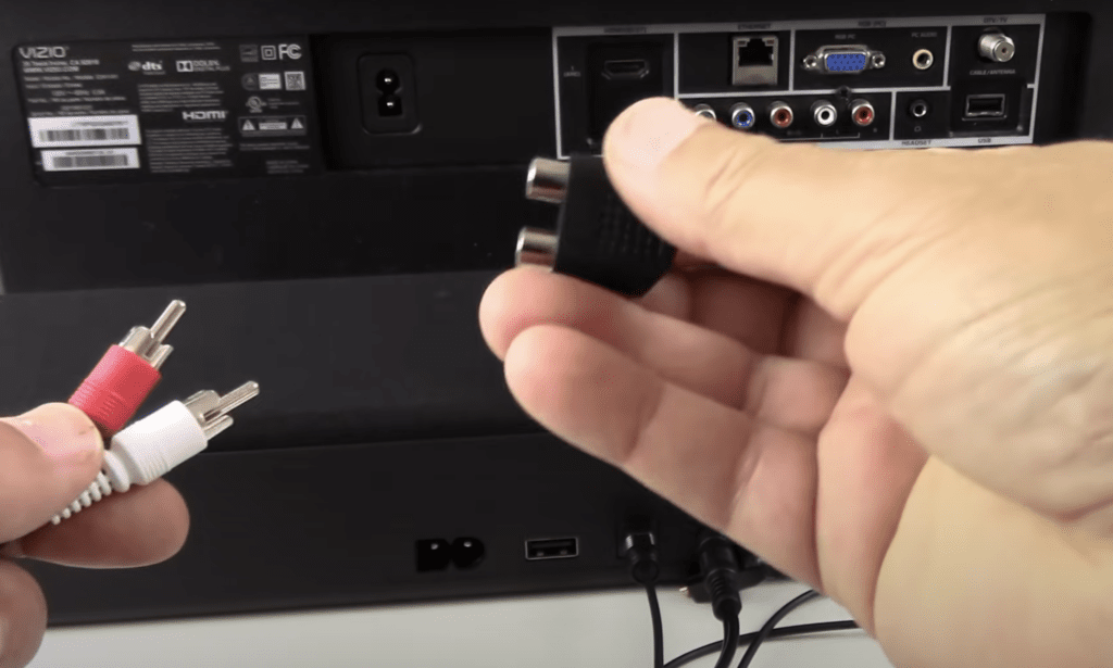 Photo of a person connecting a soundbar to a Vizio TV using an RCA cable