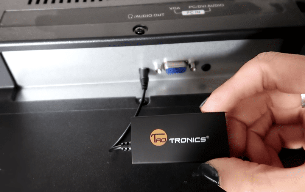 Photo of a person connecting a Bluetooth transmitter to a Vizio TV