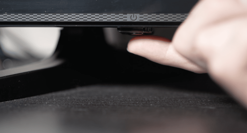 Photo of person pressing a samsung tv power button to power cycle it