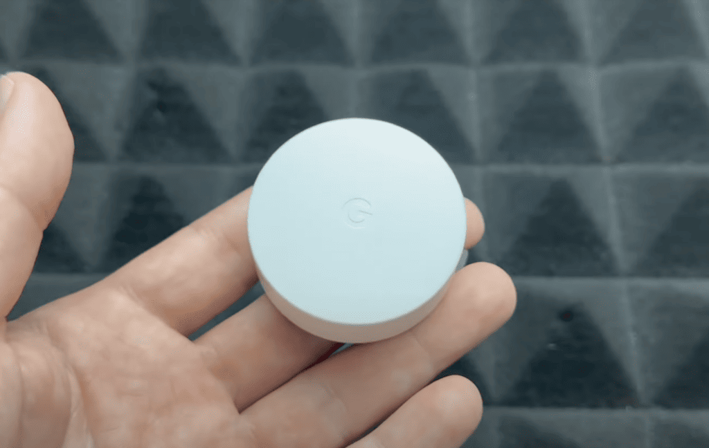 Photo of a person's hand holding a Nest Temperature Sensor