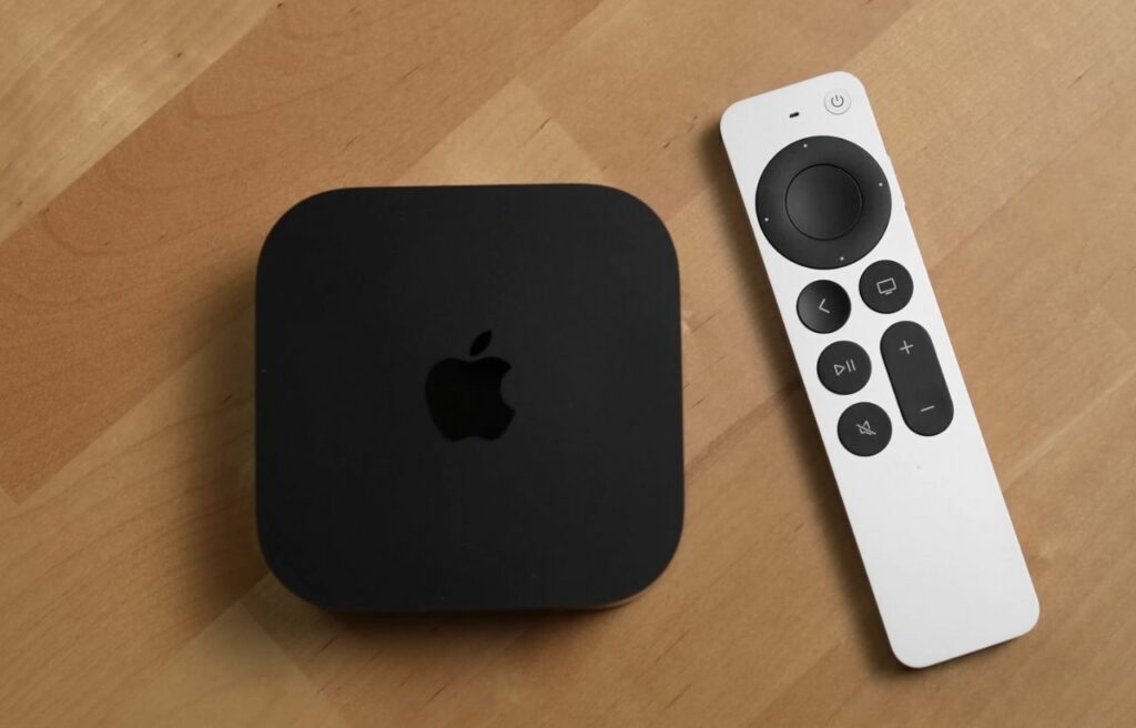 Apple TV and Apple TV remote on a wooden table